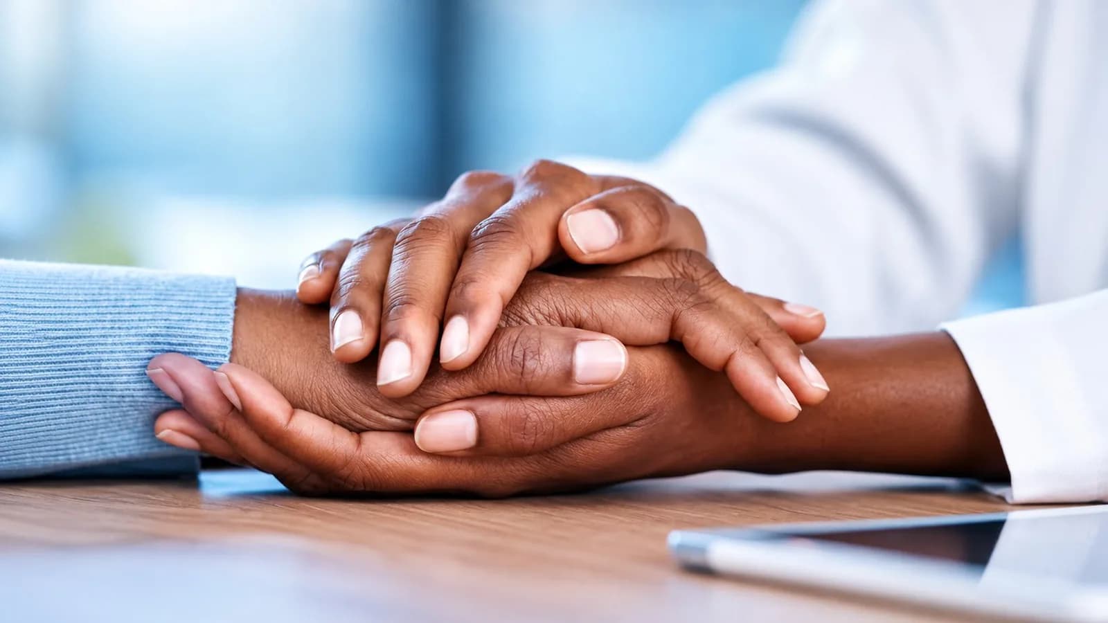 Une soignante tenant la main d'un patient